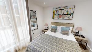 una camera con un letto con due tavoli e due lampade di The Chronicle by Supercity Aparthotels a Londra