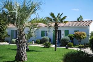 a house with palm trees in front of it at Le Petit Bois in Sainte-Marie-de-Ré