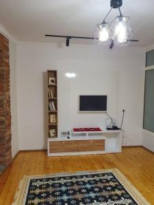 uma sala de estar com televisão numa parede branca em Shkodra 27 center house em Shkodër