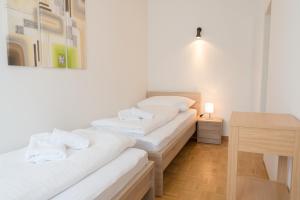two white beds in a room with a table at Apartment Seeblick in Zell am See
