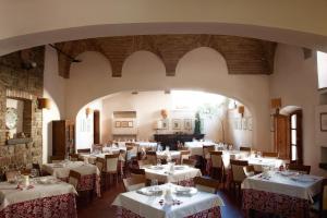 a dining room with white tables and chairs at Lo Spedalicchio in Bastia Umbra