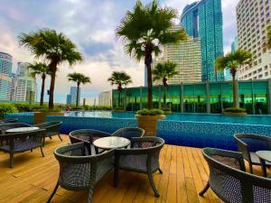 a resort with a pool and tables and palm trees at Vortex klcc in Kuala Lumpur
