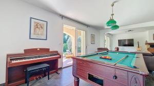 a living room with a pool table and a piano at Maison proche Dentelles Ventoux et Avignon in Sarrians