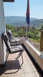 dwa krzesła siedzące na balkonie z widokiem w obiekcie Haus Sonnenschein w mieście Purasca