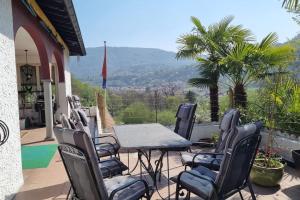 a patio with chairs and a table with a view at Haus Sonnenschein in Purasca