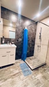 ein Bad mit einer Dusche und einem Waschbecken in der Unterkunft Lovely Aparthotel in Tsaghkadzor in Zaghkadsor