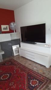 a living room with a flat screen tv on a dresser at Haus Sonnenschein in Purasca