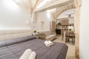 a bedroom with a large bed and a kitchen at Casa Vita 49 in Ceglie Messapica