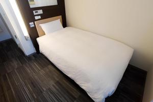 a bedroom with a white bed in a room at R&B Hotel Tokyo Toyocho in Tokyo