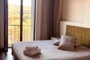 - une chambre avec un lit et des serviettes dans l'établissement Lovely Aparthotel in Tsaghkadzor, à Tsaghkadzor