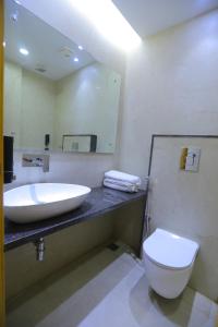 a bathroom with a sink and a toilet and a mirror at Hotel The Glitz in New Delhi