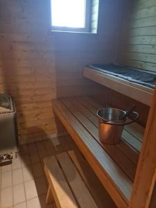 una piccola camera con un secchio su una mensola in legno di Kaunis kaksio lähellä rautatieasemaa a Hämeenlinna