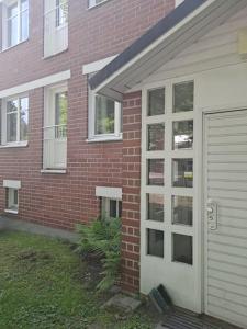 a red brick house with a white garage door at Kaunis kaksio lähellä rautatieasemaa in Hämeenlinna