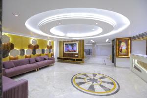 uma grande sala de estar com sofás roxos e um tecto em Hotel The Glitz em Nova Deli