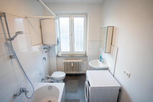 Baño blanco con aseo y lavamanos en ATRIUM - großzügige Wohnung LUDWIG79 en Ludwigshafen am Rhein