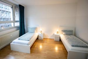 Dos camas en una habitación con dos luces. en ATRIUM - großzügige Wohnung LUDWIG79 en Ludwigshafen am Rhein