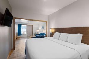 Habitación de hotel con cama grande y TV en Days Inn by Wyndham Kill Devil Hills Oceanfront - Wilbur en Kill Devil Hills