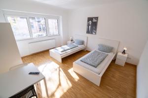 ein weißes Wohnzimmer mit einem Sofa und einem Tisch in der Unterkunft ATRIUM - moderne, großzügige Wohnung EG MARIE in Ludwigshafen am Rhein