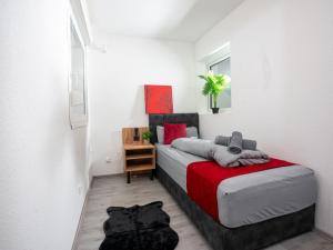 1 dormitorio con 1 cama con manta roja en SR24 - gemütliches Apartment 2 in Recklinghausen, en Recklinghausen