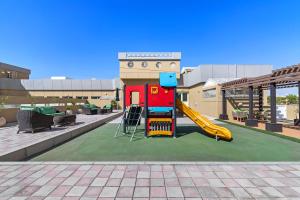 a playground with a slide in front of a building at Al Khoory Hotel Apartments Al Barsha in Dubai