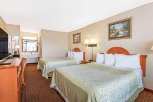 a hotel room with two beds and a television at Days Inn by Wyndham Princeton in Princeton