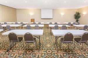 a conference room with tables and chairs and a whiteboard at Days Inn by Wyndham Princeton in Princeton