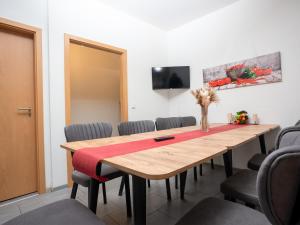 una sala de conferencias con mesa de madera y sillas en SR24 - gemütliches Apartment 2 in Recklinghausen, en Recklinghausen