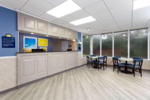 a waiting room with tables and chairs in a building at Days Inn by Wyndham Melbourne in Melbourne