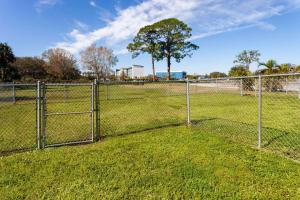 a chain link fence in a field with a tree at Days Inn by Wyndham Melbourne in Melbourne