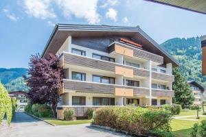 an apartment building in the mountains with trees at Apartment Seeblick in Zell am See