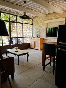 a living room with a table and a large window at mas des oliviers in Gordes