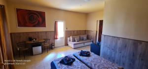 a bedroom with a bed and a living room at Panzio A mi Paradicsomunk in Véménd
