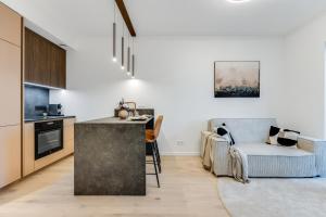 eine Küche und ein Wohnzimmer mit einem Tisch und einem Sofa in der Unterkunft Sea view 16 floor premium apartment in Tallinn
