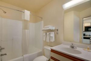 y baño con lavabo, aseo y ducha. en Days Inn & Suites by Wyndham Green Bay WI, en Green Bay