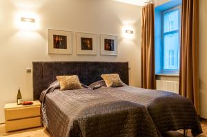 a bedroom with a bed and a window at Home & Travel Apartments - AC - Parking - City Centre - Manufaktura - OFF Piotrkowska - EC1 - ATLAS Arena - Orientarium - Monopolis in Łódź