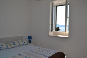 a white bedroom with a bed and a window at Villa Adria in Brist