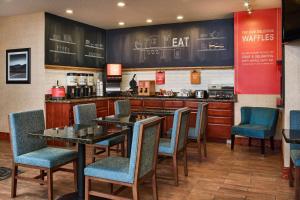 a restaurant with tables and chairs and a counter at Hampton Inn Longmont in Longmont