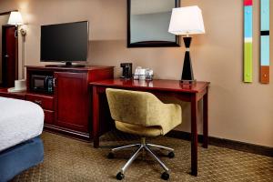 a hotel room with a desk with a television and a chair at Hampton Inn Longmont in Longmont