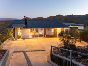 a house in the desert with mountains in the background at LANDRANI Luxury Self-catering Accommodation in Oudtshoorn