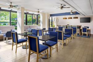 フォート・ローダーデールにあるHampton Inn Ft. Lauderdale-Cypress Creekのダイニングルーム(青い椅子、テーブル付)