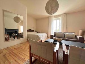 a living room with a couch and a table and a bed at Maison Favori in Le Beugnon