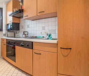 kuchnia z drewnianymi szafkami i zlewem w obiekcie Apartment Seeblick w mieście Zell am See