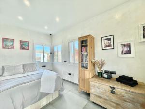 a bedroom with a bed and a wooden cabinet at LaFrenchTouch - Moderno y céntrico en Torremolinos in Torremolinos