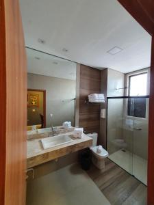 a bathroom with a sink and a toilet and a mirror at Santíssimo Resort in Tiradentes