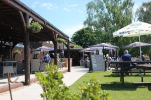 a group of people sitting at tables with umbrellas at The Dolman at Ferndown Forest Golf Course in Ferndown