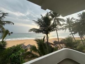 Virage Beach House @ Morava Court في هيكادوا: اطلالة على شاطئ به نخل والمحيط