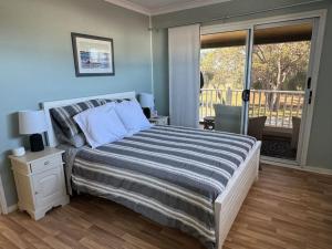 une chambre avec un grand lit et un balcon dans l'établissement Pelicans' Retreat Falcon, à Falcon