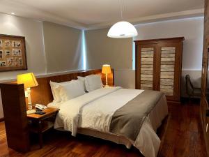 um quarto com uma cama e uma mesa com um candeeiro em Santíssimo Resort em Tiradentes
