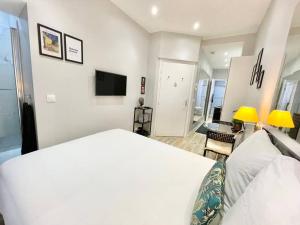 a bedroom with a bed and a couch and a tv at Charming Studette Paris La Défense in Puteaux