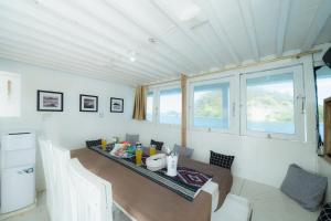 ein Esszimmer mit einem Tisch und einigen Fenstern in der Unterkunft Arimbi Liveaboard in Labuan Bajo
